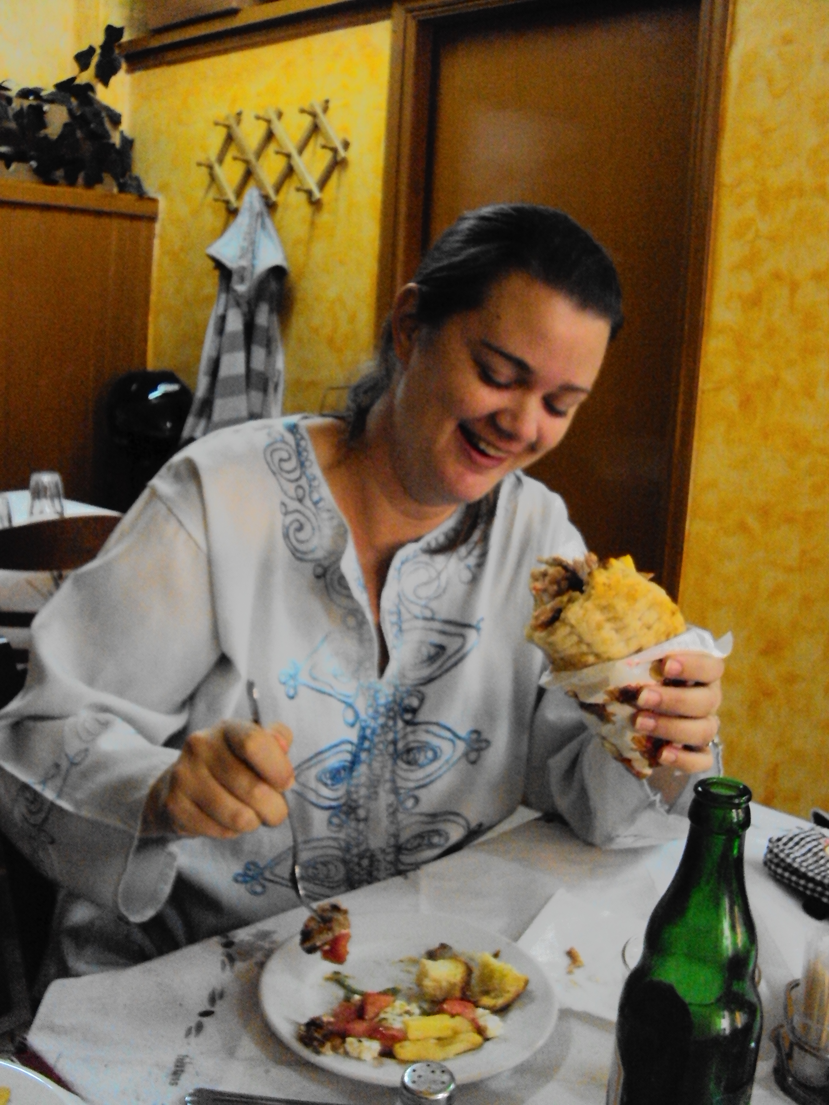 girl eating pork wrap in greece gyros