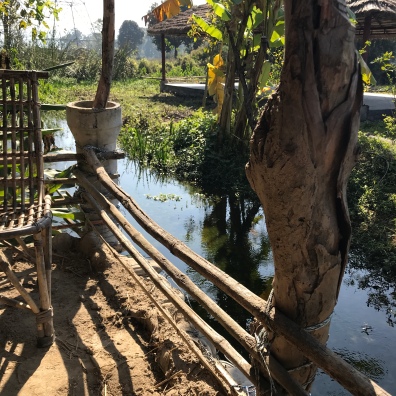 Wicker chair and railing along stream at farm in Rishikesh India